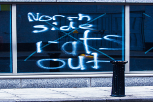 Text auf einem Fenster und eine Absperrstange auf der Straße.