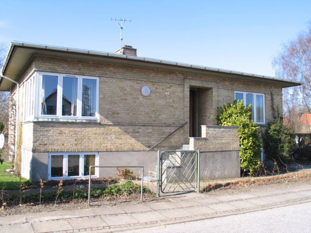 Zweizimmer-Detached-Bungalow zum Verkauf in St Johns Wood, Swindon, mit Dach, Fenstern, Tür, Treppe, Metallzaun, Pflanzen, Gras, Bäumen, Satellitenschüssel und bewölktem Himmel.