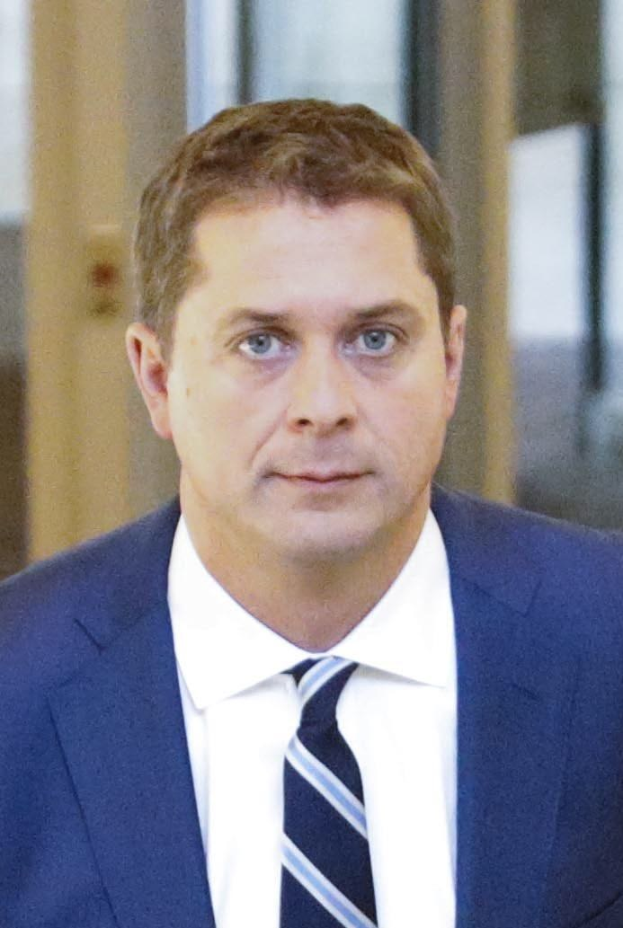 Ein Mann im Anzug und Krawatte geht einen Flur entlang mit einem unscharfen Hintergrund, sieht besorgt aus.