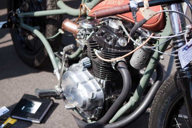 Mehrere Motorräder auf einem Parkplatz mit einem Buch auf einem der Sitze