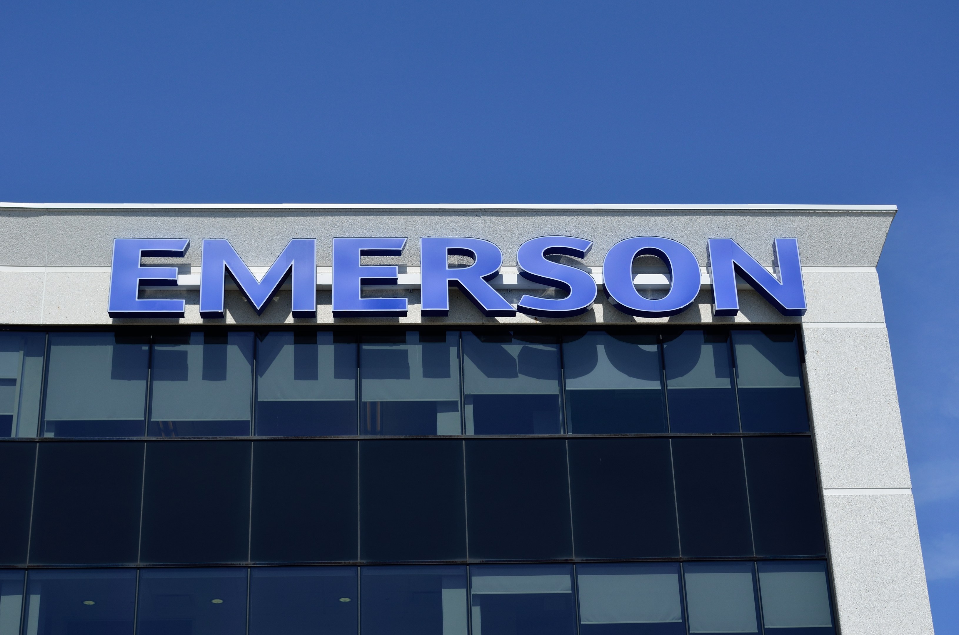 Emerson-Logo an einer Gebäudefassade mit dem Text "Emerson investiert 1,5 Milliarden USD in den USA".