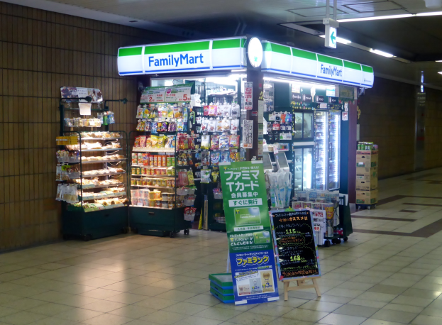 Convenience Store Inneneinrichtung mit "FamilyMart"-Schilder, Lebensmittelregalen, Kühlgeräten und Beleuchtung.
