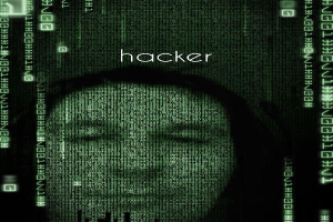 Das Gesicht eines Hackers auf einem Computerbildschirm umgeben von Binärcode und dem Wort "Hacker."