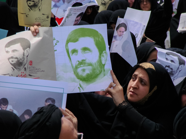 Eine Gruppe iranischer Frauen in schwarzer Kleidung, einige mit Brille, hält Fotos von Präsident Mahmoud Ahmadinejad während einer Demonstration in Tehran hoch.