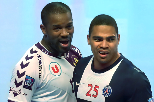 Zwei Männer in weißen und blauen T-Shirts auf einem Fußballfeld, die einen Sieg feiern, mit einem hellblauen Hintergrund.