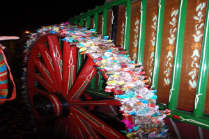 Ein geschmücktes Rad neben einem Eisengitter.