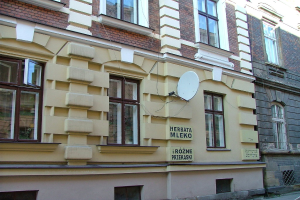 Ziegelgebäude mit Glasfenstern, Graffiti an den Wänden und eine Satellitenschüssel auf einer der Wände.