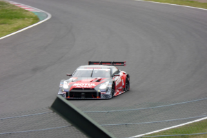 Nissan GT-R Nismo GT3-Rennwagen auf der Nürburgring 24 Stunden-Strecke mit grünem Gras auf beiden Seiten.