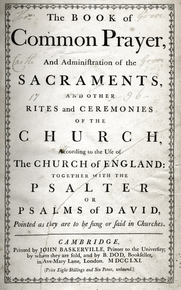 Ein altes Buch mit dem Titel "The Book of Common Prayer and Administration of the Sacraments, Rites and Ceremonies of the Church of England" liegt aufgeschlagen vor einer Seite mit schwarzem Text.
