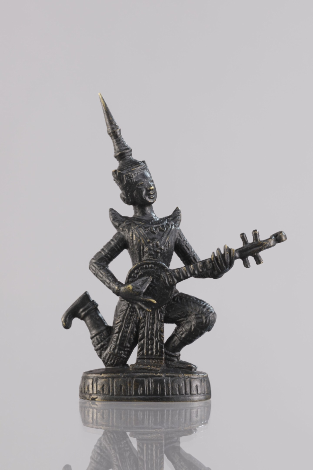 Bronzestatue eines Mannes, der eine Gitarre spielt, vor weißem Hintergrund.