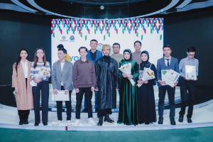 Gruppe von Menschen auf einer Bühne mit Blumensträuschen und Urkunden, vor dem Hintergrund "Jugend Solar Awards 2019"