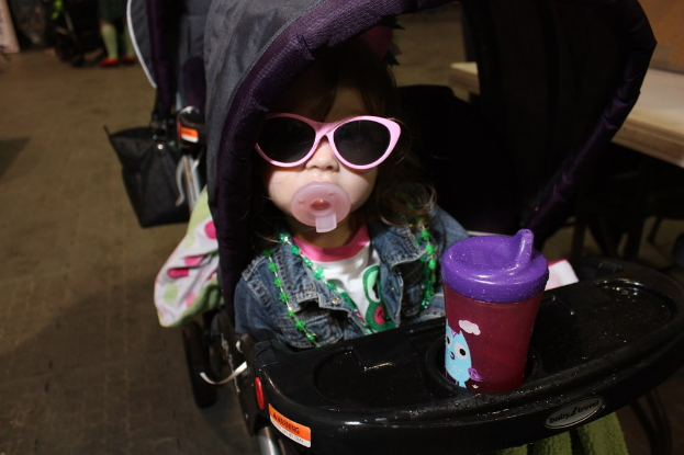 Ein Kind sitzt in einem Laufgänger auf der Straße.