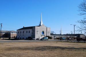 Eine Stadtlandschaft mit zahlreichen Gebäuden, Autos auf der Straße und Bäumen am Boden.
