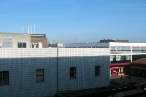 Eine Straßenszene mit Gebäuden und Geschäften, die einige Menschen zwischen ihnen zeigen.