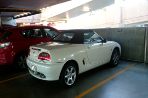  Autos in einem Keller mit einem Rohr am Dach und einem weiteren Gebäude oben rechts zu sehen.
